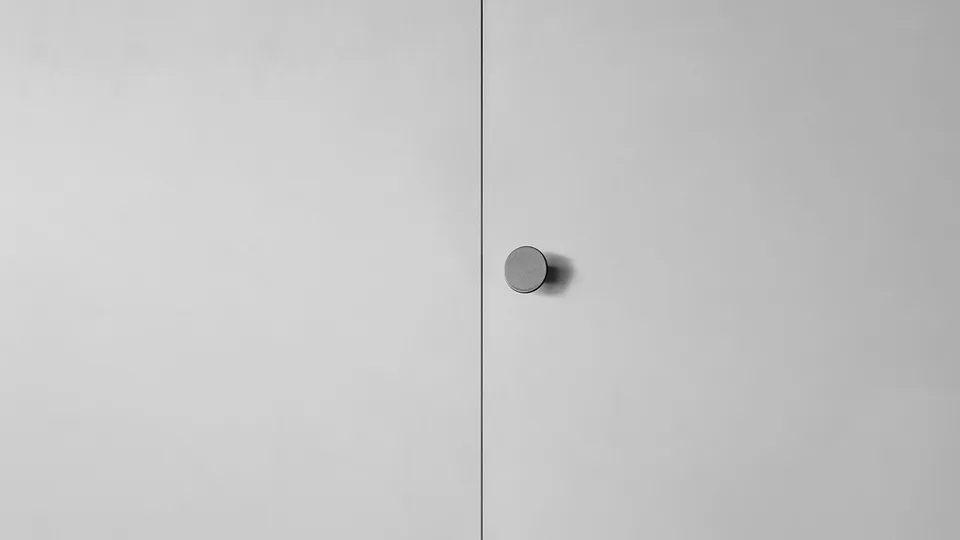 Simply, вариант ручки: круглая серая ручка-кнопка рядом со стыком двух светлых матовых дверей